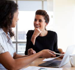 Two women discussing investing in your dental practice