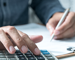 Man working on finances with a calculator