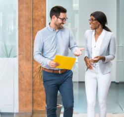 Two colleagues walk down the hall at their office