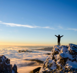 Man on top of a mountain peak
