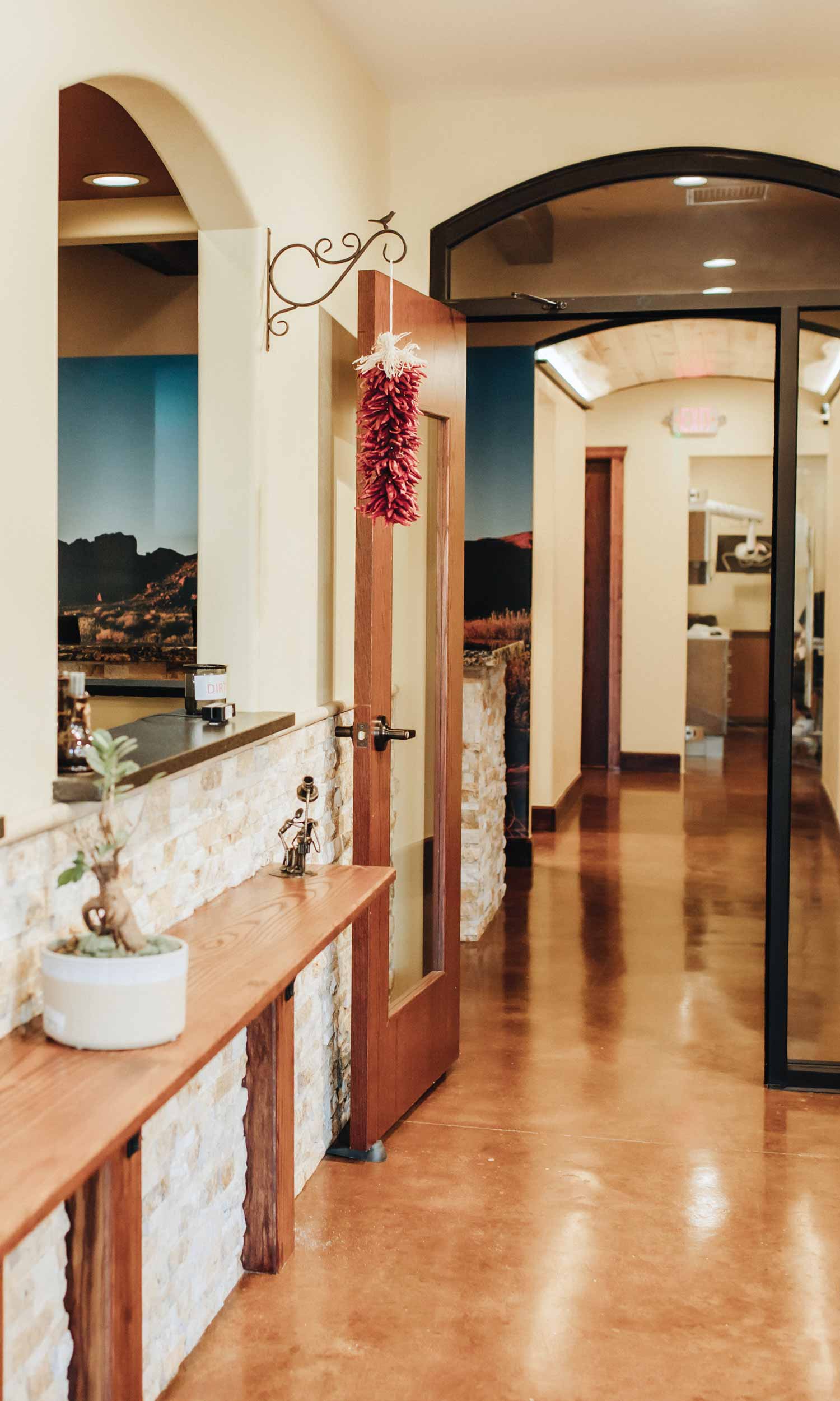 Those touches continue in the arched doorways and windows, through the natural wood elements incorporated with the warm natural stone, and in the hanging peppers reminiscent of a market.