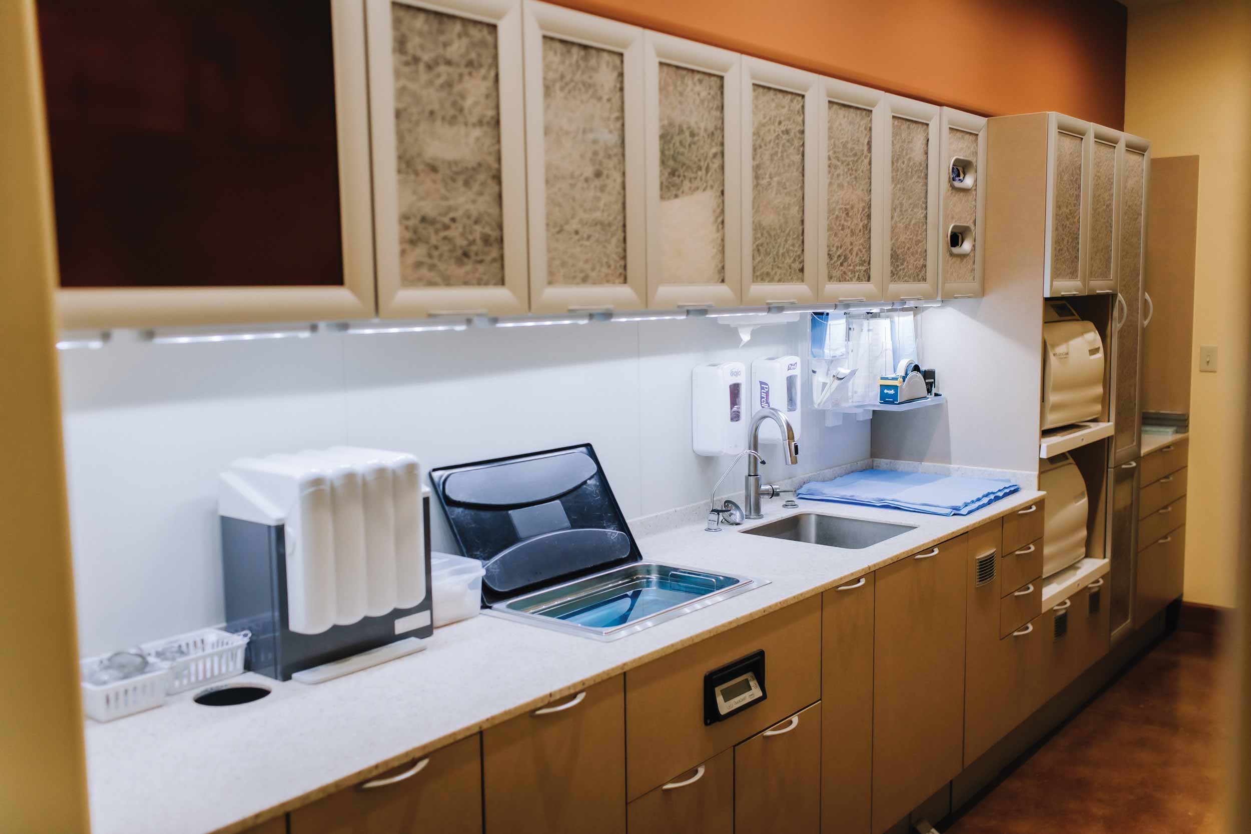 The Sterilization Center, at the heart of the Broken Arrow practice, continues the Santa Fe inspiration echoing the clay paint color on the wall and the natural textures in the upper cabinets.