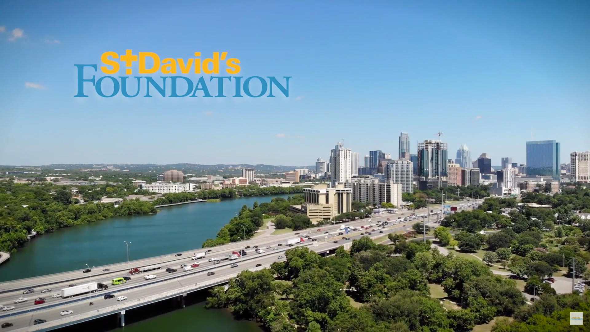 A logo for St. David's Foundation is superimposed in the top left corner of an image of the freeway heading into Austin, TX.
