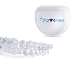 Introducing OrthoClear™ Aligners – the newest clear aligner treatment from DenMat and Burkhart Dental Supply. The image highlights an example of what the clear aligners look like that the case to store them. The deep blue and light blue OrthoClear® logo is on the case.