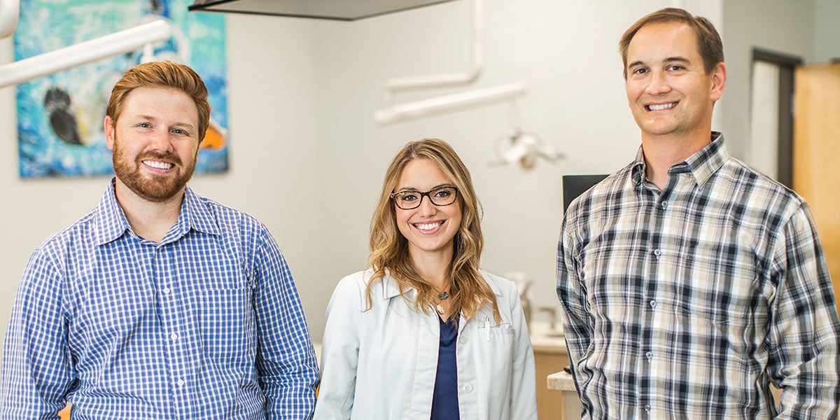 From left to right, Josh Mize, Dr. Sam, and Arne Valdez, Burkhart Account Manager. The trio stands in front of the operatories facing the camera, smiling.