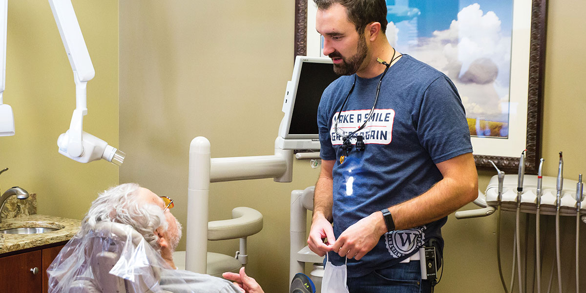 Dr. Cody Winterholler works with a Veteran. The Veteran is laying down in the chair. 